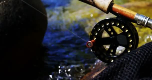 Vara de pesca da mosca, bobina e gancho na rocha — Vídeo de Stock