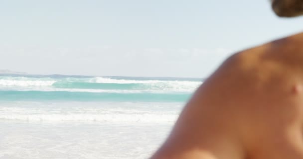 Мужчина-серфер, стоящий на пляже — стоковое видео
