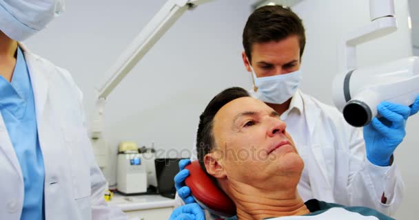 Dentista examinando um paciente do sexo masculino com ferramenta dentária — Vídeo de Stock