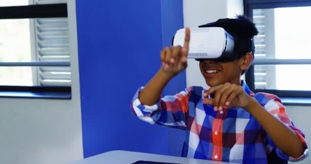 Schoolboy usando fone de ouvido de realidade virtual em sala de aula — Vídeo de Stock