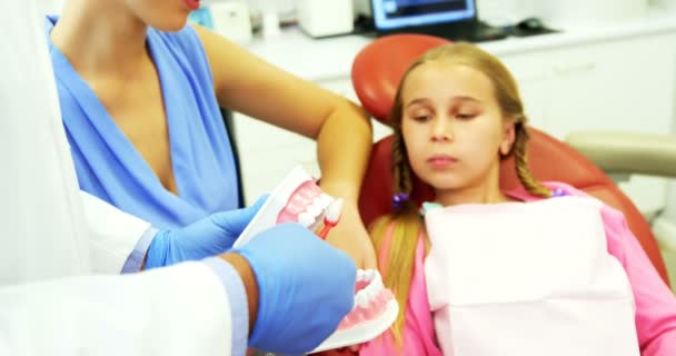 Dentista mostrando jovem paciente como escovar os dentes — Vídeo de Stock