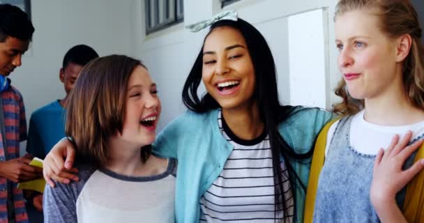 Χαμογελώντας μαθήτριες στέκεται με τα χέρια της γύρω στο διάδρομο — Αρχείο Βίντεο