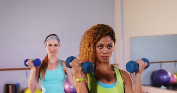 Vastbesloten vrouwen uitvoeren van aerobics met halters — Stockvideo