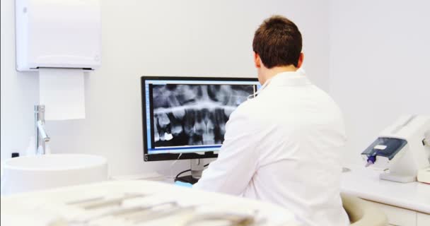 Dentista attento esame dei raggi X rapporto sul computer — Video Stock