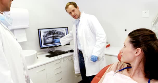 Dentista mostrando um raio-x de dentes para paciente do sexo feminino no computador — Vídeo de Stock