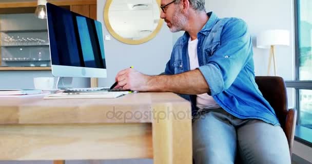 Αρσενικό γραφίστας χρήση tablet γραφικών στο γραφείο — Αρχείο Βίντεο
