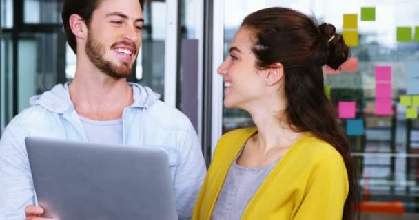 Ejecutivos masculinos y femeninos discutiendo sobre el portátil — Vídeo de stock