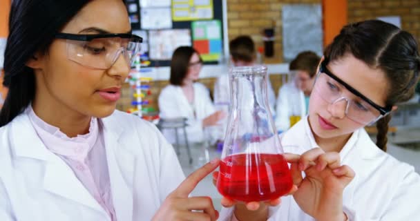 Niñas de la escuela experimentando con químicos en laboratorio en la escuela — Vídeos de Stock