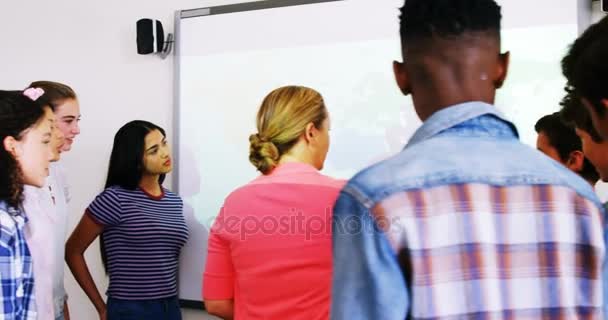 Profesor y estudiantes discutiendo sobre mapa del mundo en pizarra blanca en el aula — Vídeo de stock