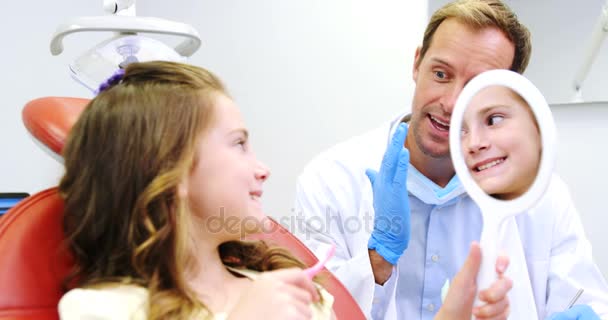 Dentista ensinando menina a uma escova de dentes — Vídeo de Stock