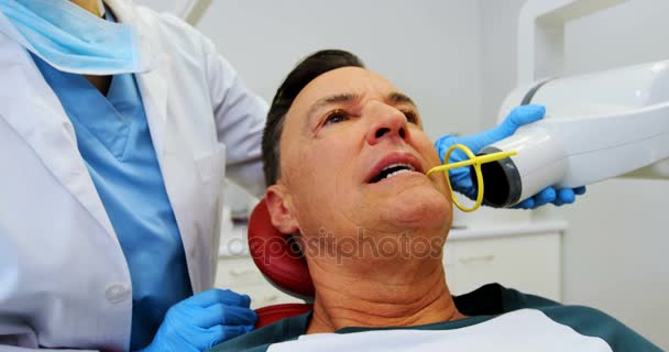 Dentist examining a male patient with tool — Stock Video