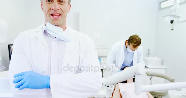 Улыбающийся стоматолог, стоящий со скрещенными руками — стоковое видео