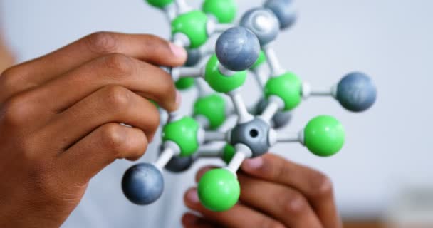 Школьник экспериментирует с молекулярной моделью в лаборатории в школе — стоковое видео