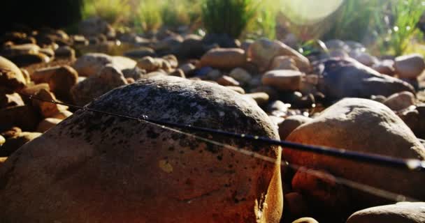 Mosca caña de pescar, carrete y gancho en roca — Vídeos de Stock