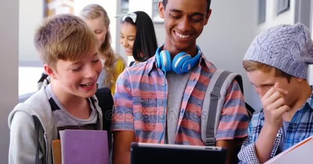 Студенти стоять з ноутбуком і цифровим планшетом в коридорі — стокове відео