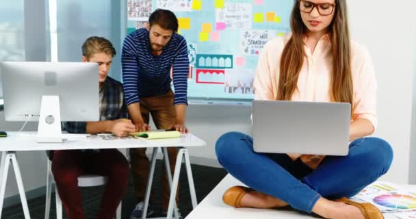 Diseñadora gráfica femenina usando laptop en oficina — Vídeos de Stock