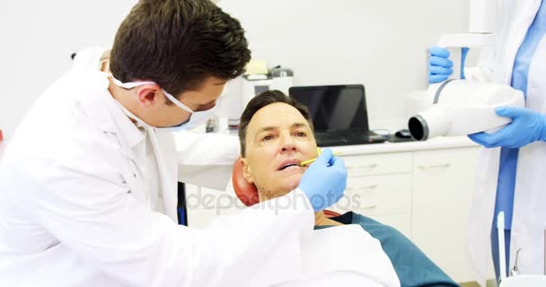 Dentista examinando um paciente do sexo masculino com ferramenta — Vídeo de Stock