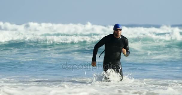 Mężczyzna surfer uruchomiona w plaży — Wideo stockowe
