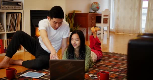 Ζευγάρι χρησιμοποιώντας φορητό υπολογιστή στο σαλόνι — Αρχείο Βίντεο