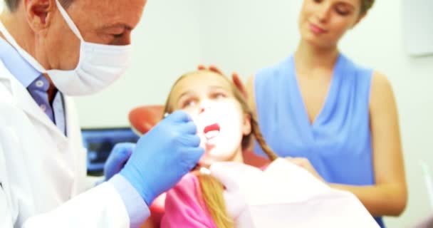 Dentista che esamina un giovane paziente con uno strumento — Video Stock