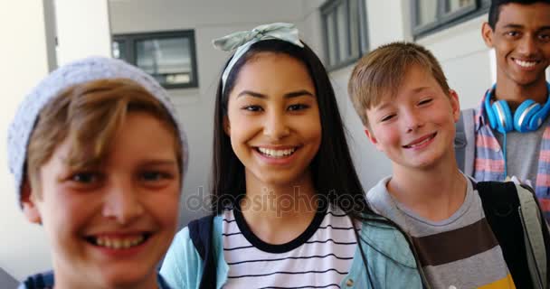 Uśmiechający się uczniowie stojący z notebooka w korytarzu — Wideo stockowe