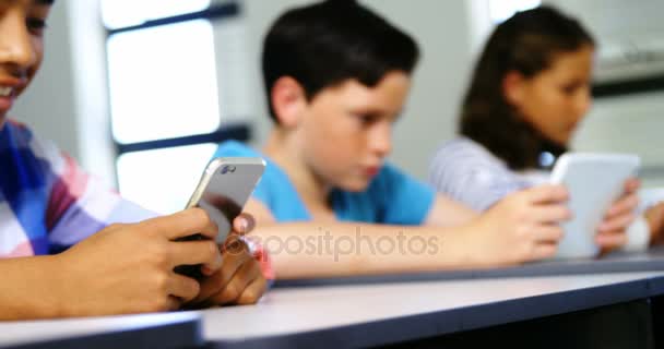 Σπουδαστές που χρησιμοποιούν ψηφιακό tablet και κινητό τηλέφωνο στην τάξη — Αρχείο Βίντεο
