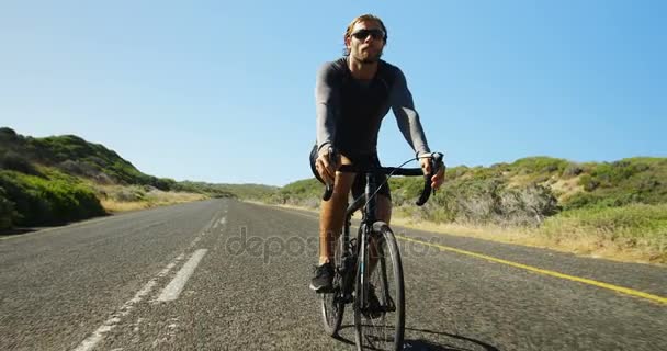 Triatleta hombre ciclismo en el campo carretera — Vídeos de Stock