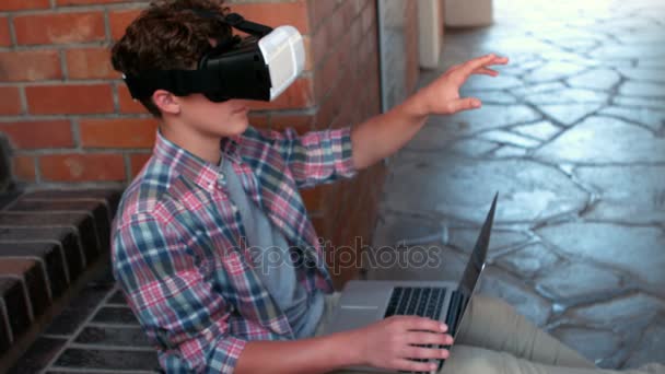 Uczniak podczas korzystania z laptopa na sobie słuchawki do witalności — Wideo stockowe