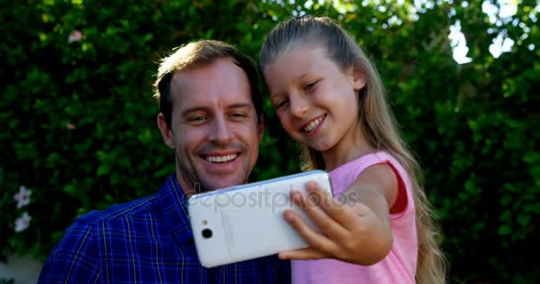 Отец и дочь делают селфи на мобильном телефоне в парке — стоковое видео