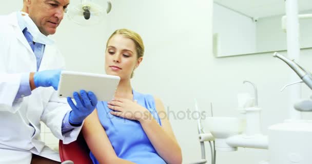 Tandläkare som diskuterar över digitala tablett med kvinnlig patient — Stockvideo