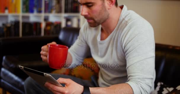 Man using digital tablet while having coffee — Stock Video