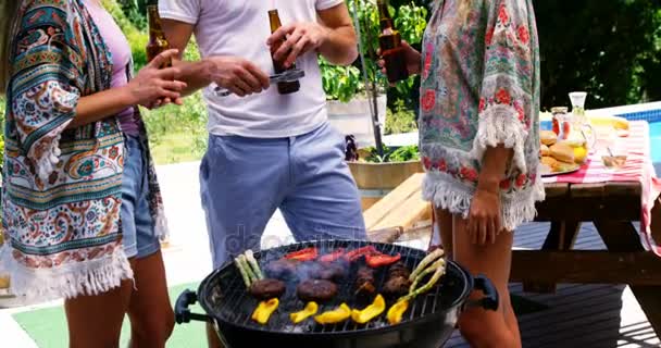 Gruppo di amici che bevono una bottiglia di birra mentre preparano il barbecue — Video Stock