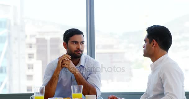 Compañeros de negocios interactuando entre sí mientras desayunan — Vídeos de Stock