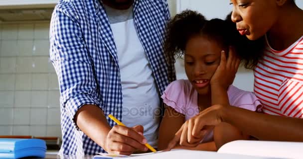 Родители помогают дочери в выполнении домашних заданий — стоковое видео