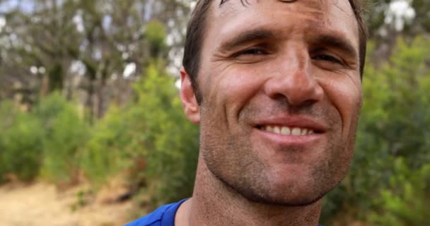 Hombre sonriendo durante la carrera de obstáculos — Vídeos de Stock