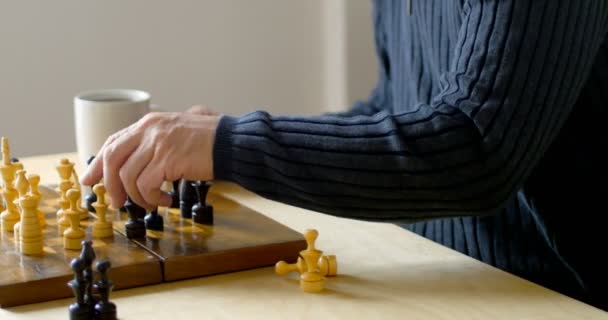 Homem jogando xadrez enquanto toma café na sala de estar — Vídeo de Stock