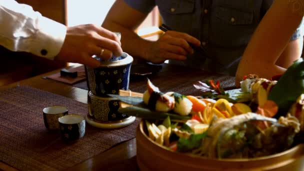 Bandeja de sushi e bebida na mesa do restaurante — Vídeo de Stock