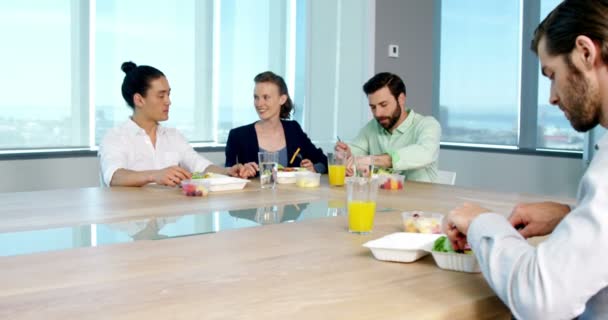 Ejecutivos de negocios sonrientes comiendo en la oficina — Vídeos de Stock