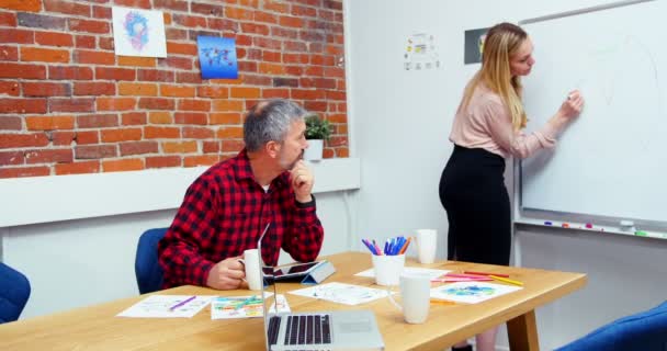 Executivos discutindo sobre quadro branco — Vídeo de Stock