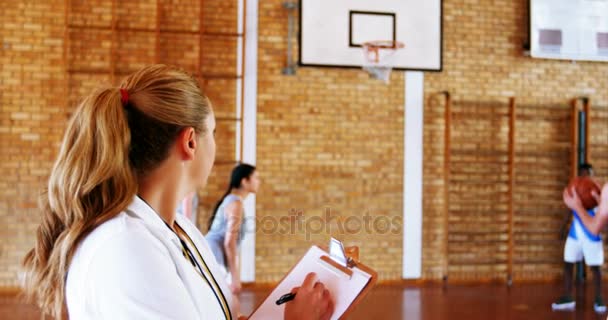 Female coach writing on clipboard — Stock Video