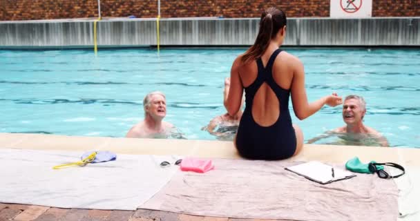 Treinador de natação interagindo com idosos — Vídeo de Stock