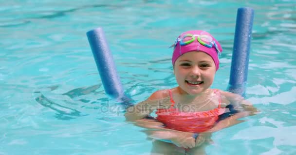 Portret van een jong meisje gebaren in het zwembad — Stockvideo