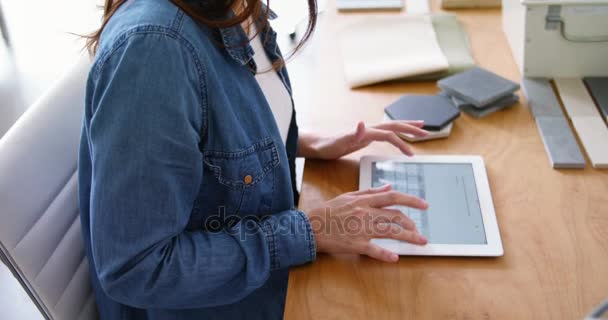 Female executive sitting at desk and using digital tablet — Stock Video