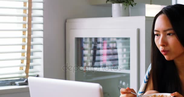 Schöne Frau mit Müsli, während mit Laptop — Stockvideo