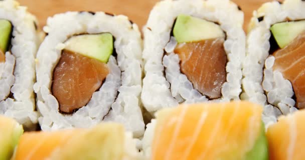 Rolos de sushi com salmão em recipiente de plástico — Vídeo de Stock