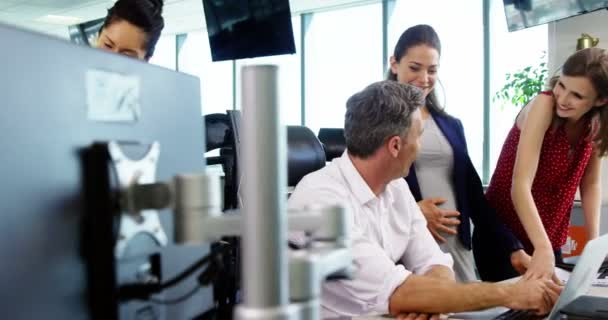 Ejecutivos discutiendo sobre portátil en la oficina — Vídeo de stock