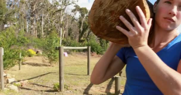 Mujer llevando tronco de madera pesado — Vídeo de stock