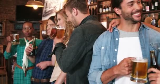 Grupo sorridente de amigos interagindo enquanto bebem uma garrafa de cerveja — Vídeo de Stock