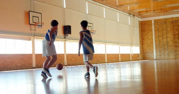 Schooljongens spelen basketbal in basketbalveld — Stockvideo