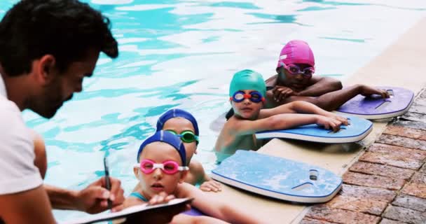 Entrenador dando clases de natación a sus estudiantes — Vídeos de Stock